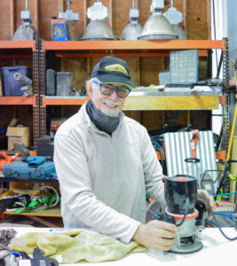 John smiling with sander in the workshop