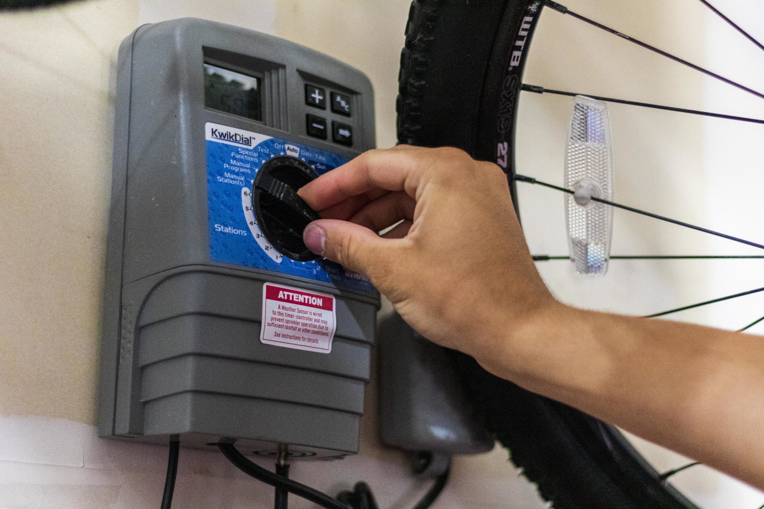 A Slow the Flow technician adjusting the schedule on an irrigation control clock