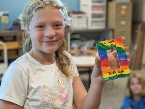 Student holding decorated light switch cover