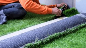 person rolling up artificial turf from the ground