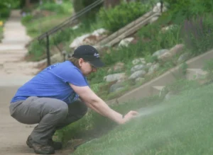 Neka Sunlin kneels at a Slow the Flow sprinkler evaluation.