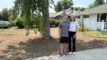 Two homeowners stand in their yard after the grass was removed.