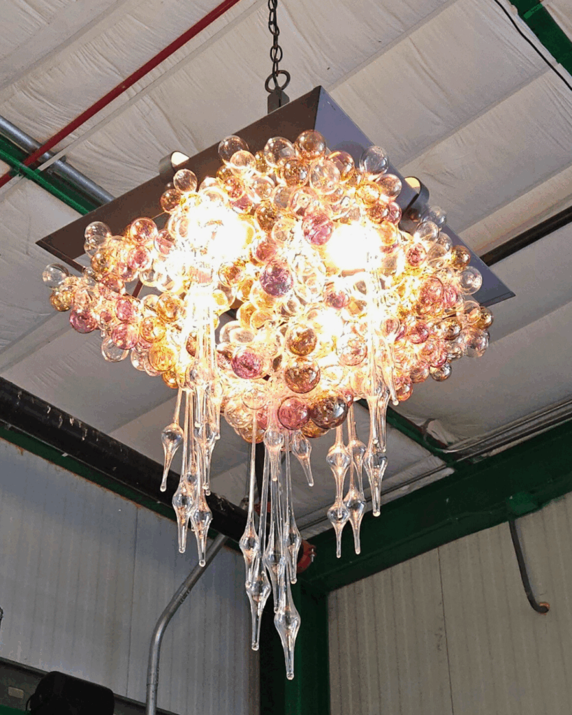 An elaborate glass chandelier hanging from the ceiling of the Resource Central warehouse.