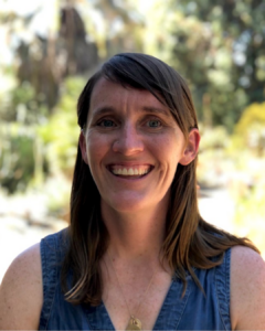 headshot of a woman with brown hair and blue shirt