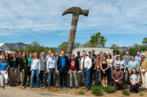 Earth Day 2026 Event with Governor Jared Polis, Mayor Aaron Brockett, Resource Central President & CEO Neal Luri, Eco-Cycle Executive Director Suzanne Jones, and community leaders, and staff standing next to a 15-foot hammer sculpture