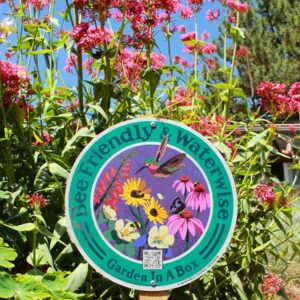 Garden In A Box sign among pink and green plants
