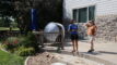 A Slow the Flow technician and a homeowner talking on a backyard patio.