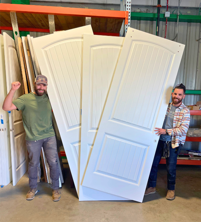 Two Resource Central team members standing with three white doors
