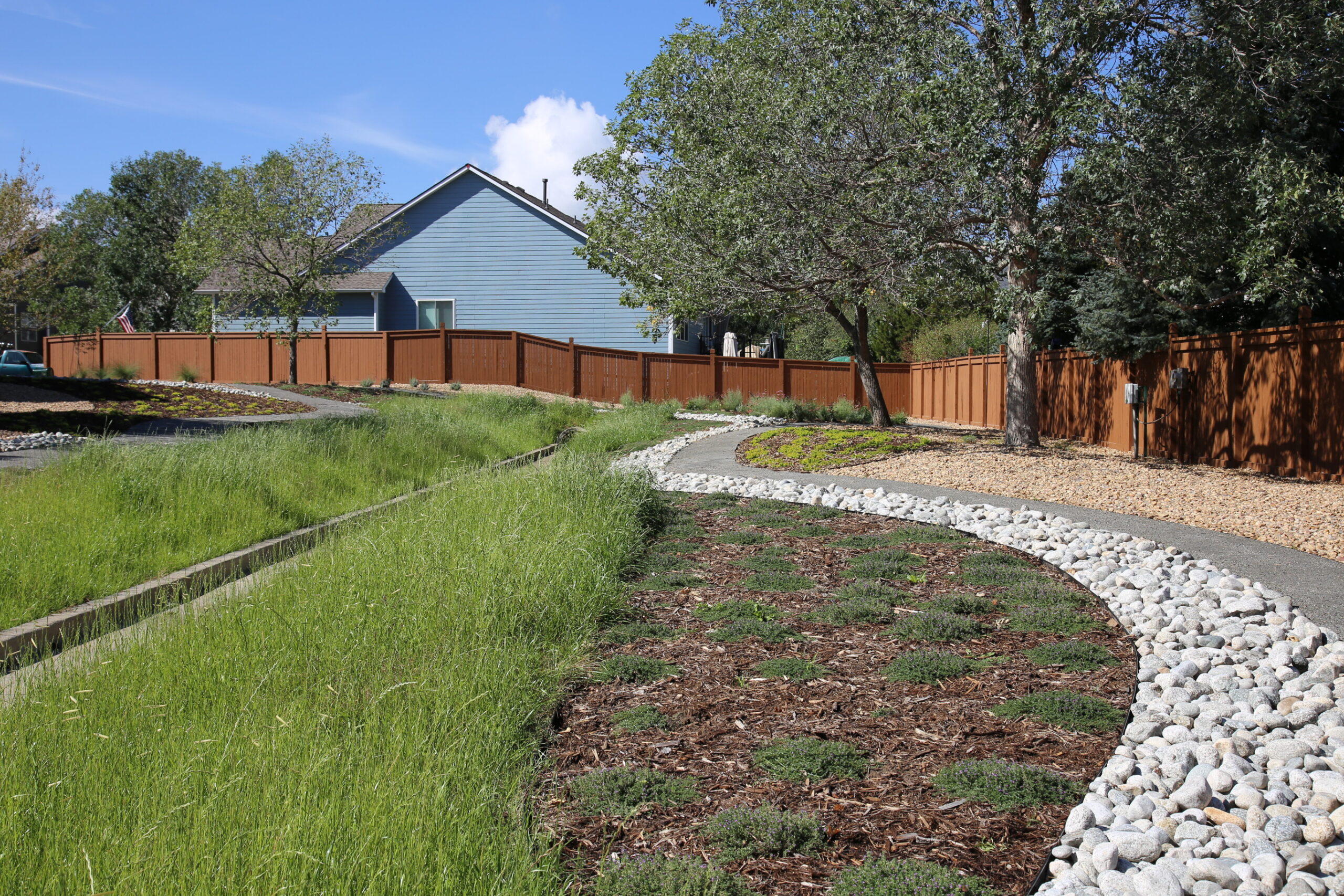 tall grass, groundcover plants, and a rocky footpath